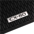 Srebrne logo Mazdy CX-80 na dywaniku gumowym.