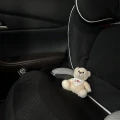 Pluszowy biały miś przytulanka Mazda bezpiecznie siedzi w foteliku.